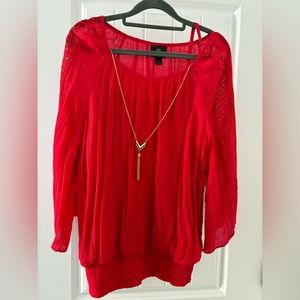 Red blouse with lace detail and gold color necklace